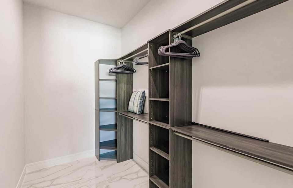 Organized custom shelving and ample hanging space in the primary closet.