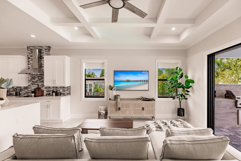 Relax in this airy open-concept living space with designer finishes and seamless access to the outdoor kitchen and pool patio.