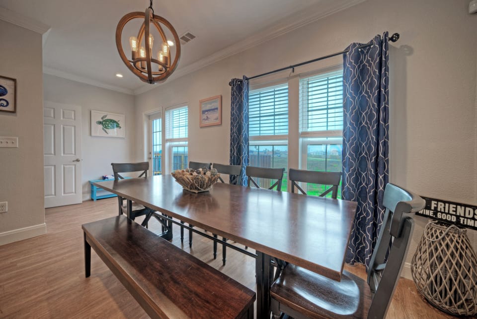 Gather around the dining table for shared meals, with coastal accents and balcony views nearby.