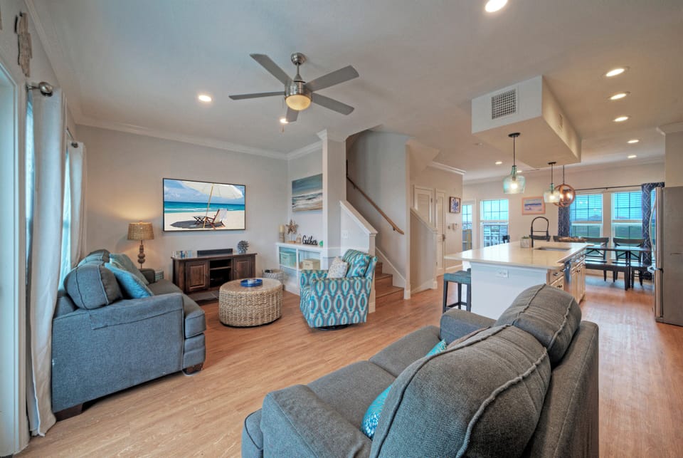 Spacious open-concept living with coastal décor, comfy seating, and easy flow into the kitchen and dining area.