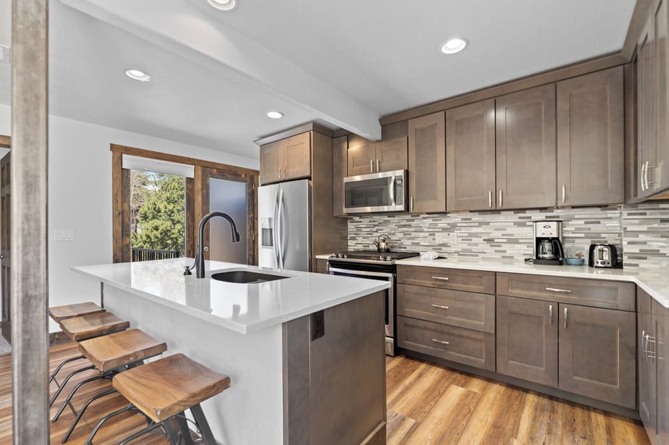 Step into your fully equipped kitchen with sleek countertops, modern appliances, and a breakfast bar perfect for morning coffee or casual meals with friends and family.