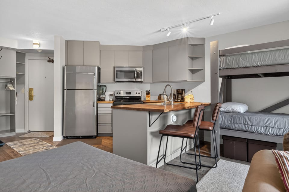 Relax in your thoughtfully designed studio with a fully-equipped kitchen, breakfast bar for quick bites, and cozy bunk beds—everything you need for a memorable mountain getaway.