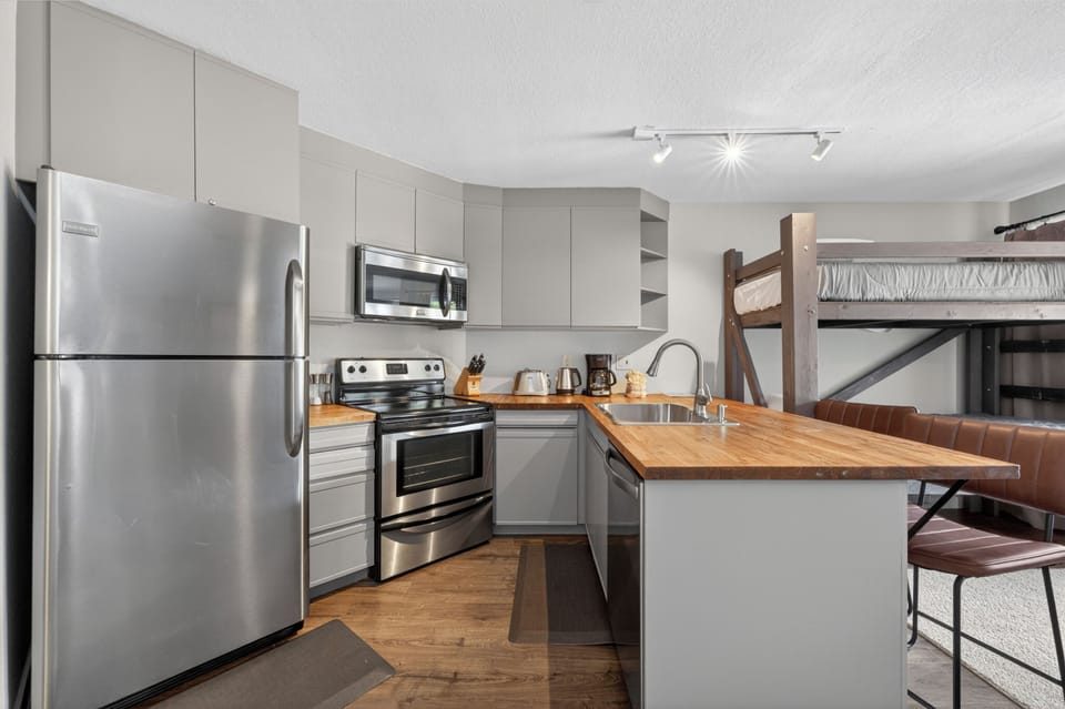 Prepare your favorite meals in this fully equipped kitchen with stainless steel appliances, butcher block counters, and an inviting island perfect for casual dining.