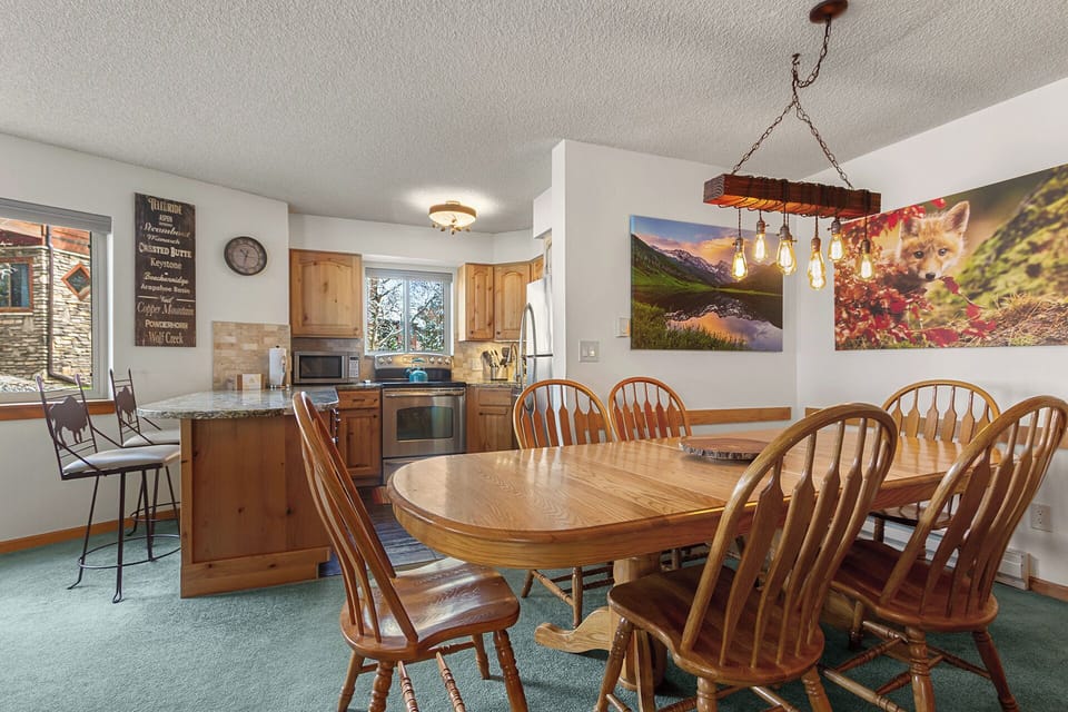 Gather around the welcoming wooden dining table where your group can share meals and make memories together, with a fully-equipped kitchen at your fingertips and mountain-inspired décor setting the scene.