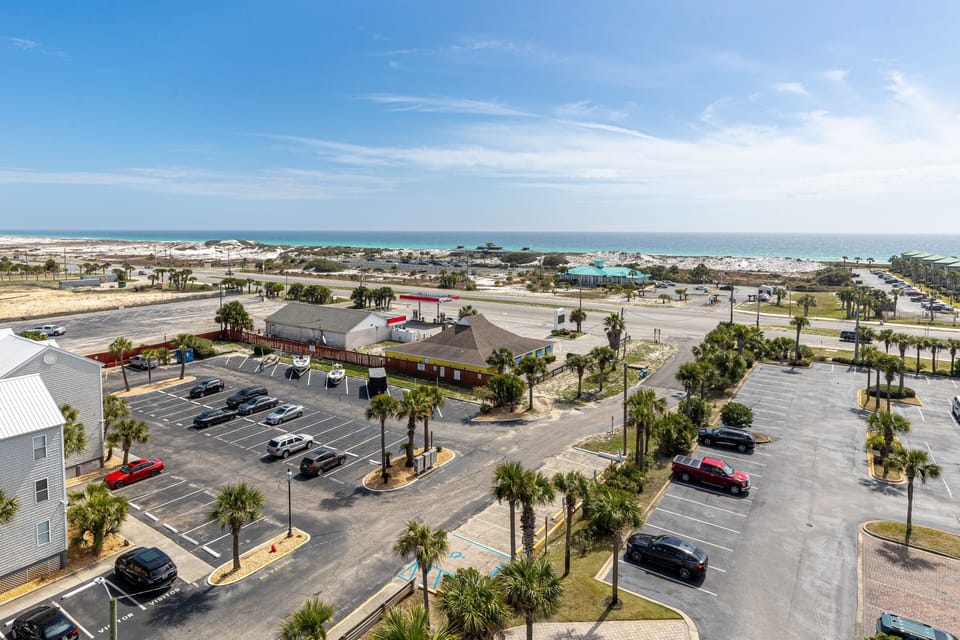 Aerial view of the beachfront area with convenient parking and nearby amenities just steps from the sandy shore.