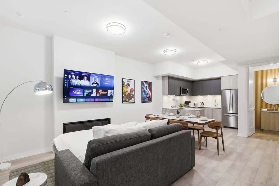 Open-concept living and dining area with Smart TV, fireplace, and modern kitchen