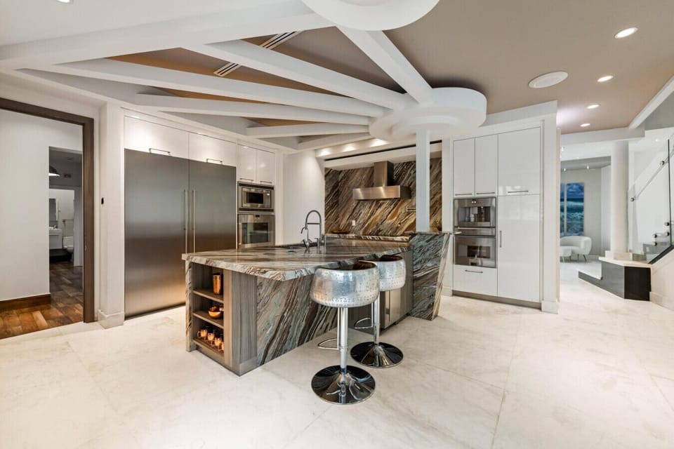 Gourmet kitchen featuring a stunning marble island with breakfast bar seating
