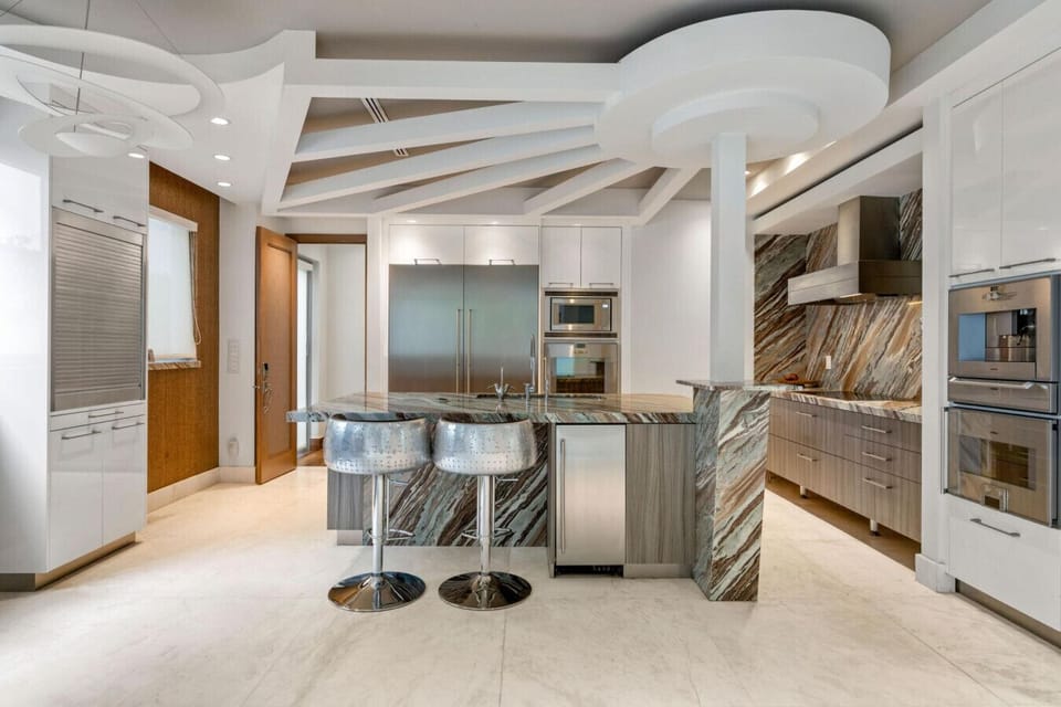 Chef’s kitchen featuring expansive marble island with breakfast bar and high-end finishes