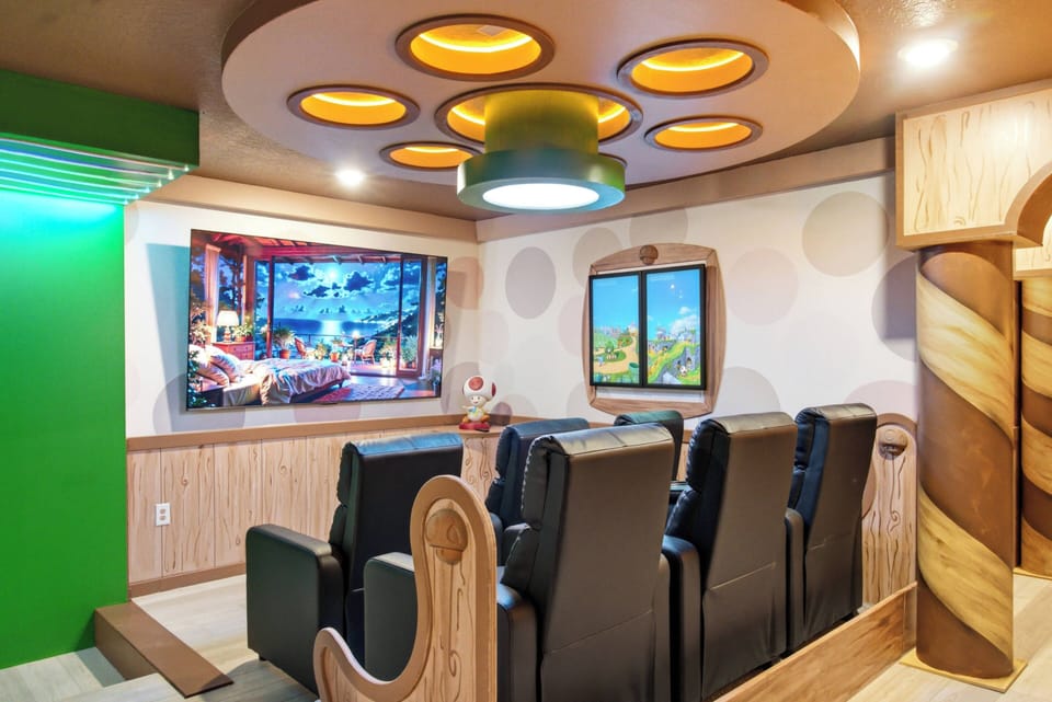 Enjoy a lively entertainment room with comfy black recliners set for movie nights. The fun decor features playful wall art and unique circular lighting, creating an exciting atmosphere for your stay.