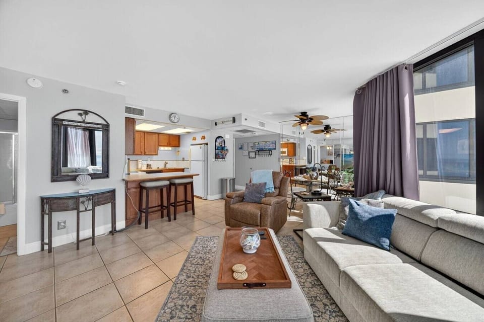 Bright and spacious open-concept living area with coastal décor and breakfast bar seating.