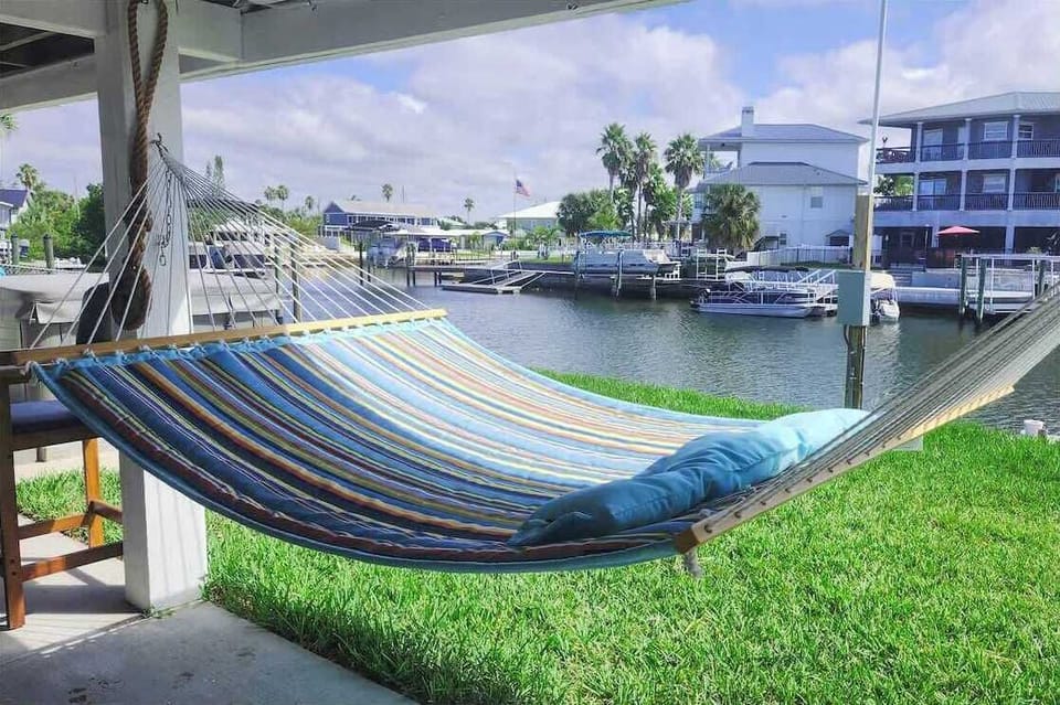Shaded hammock lounge overlooking the canalfront with steady coastal breeze.