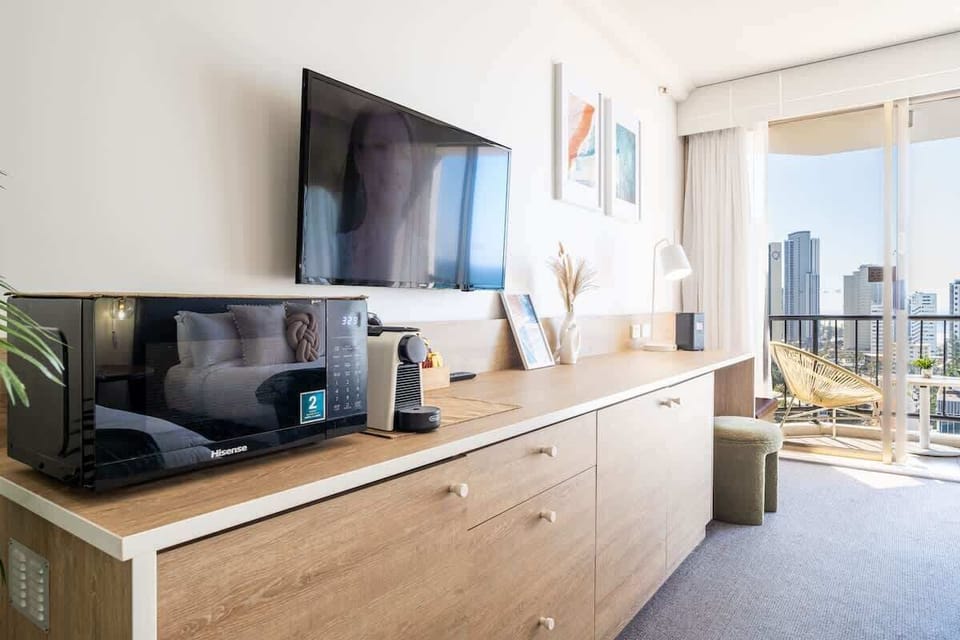 Relax in a stylish and well-lit room featuring a TV, workspace, and natural light