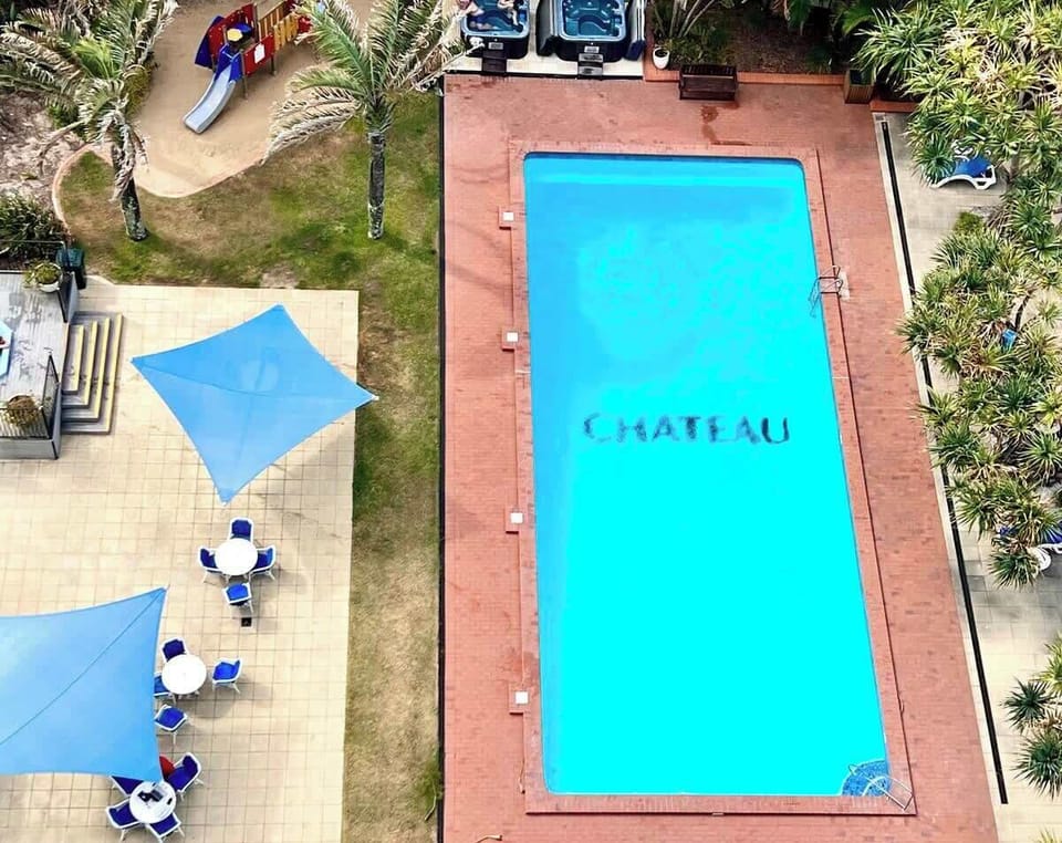 Resort outdoor pool surrounded by sun loungers and tropical gardens