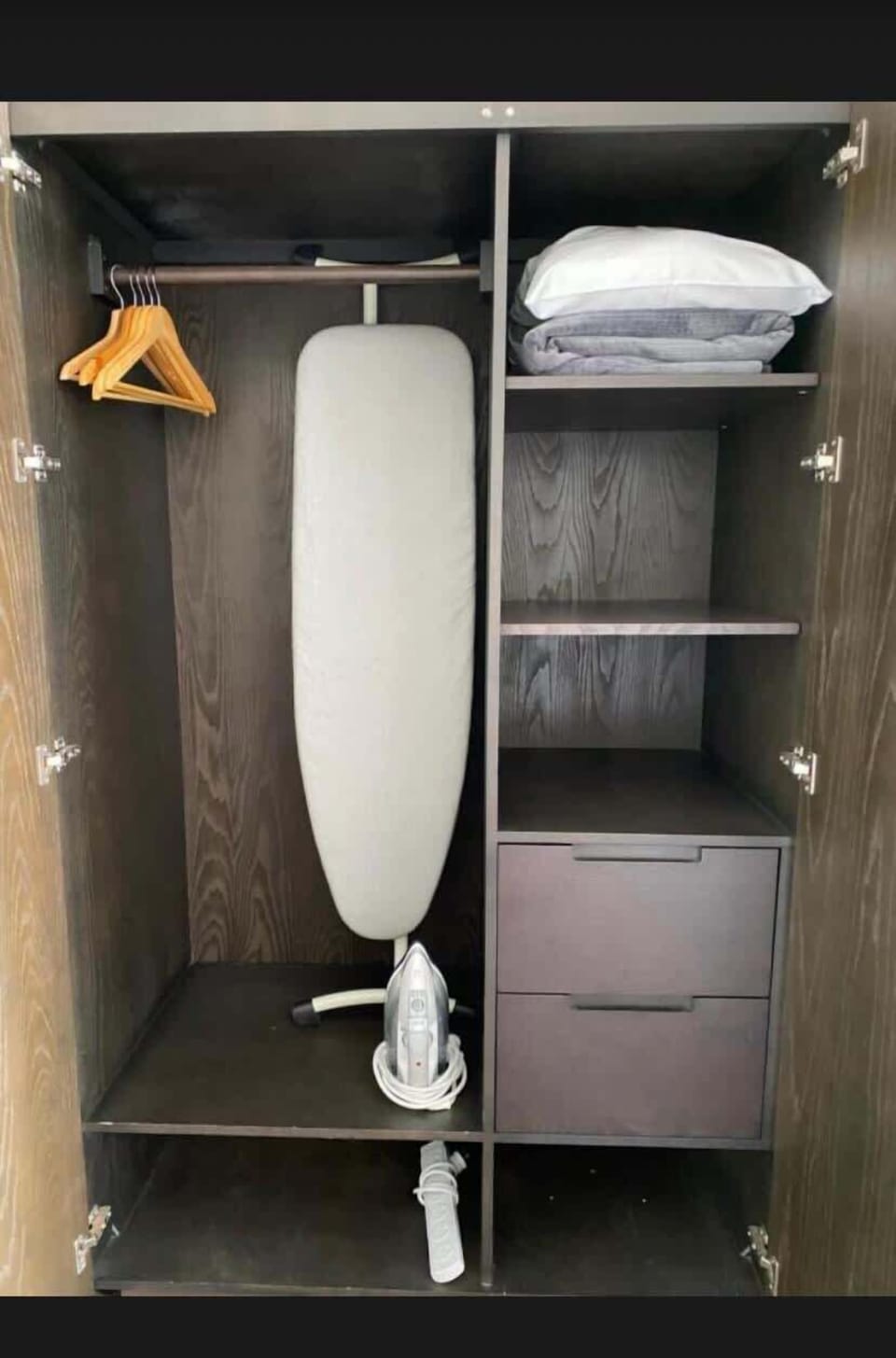 Spacious wardrobe with ample storage for longer stays, complete with an ironing board