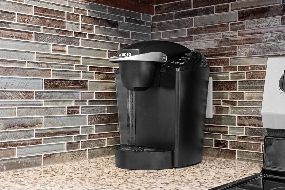 Modern kitchen coffee station with Keurig and stylish tile backsplash
