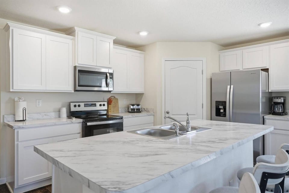 Fully equipped kitchen featuring generous counter space and bar seating for easy dining, conversation, and entertaining.