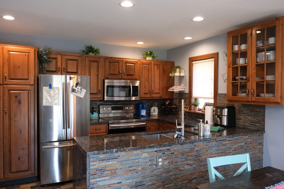 Fully equipped kitchen with stainless steel appliances and island.