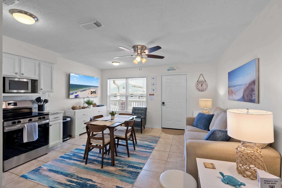 Open living, dining, and kitchen area with a clean coastal feel
