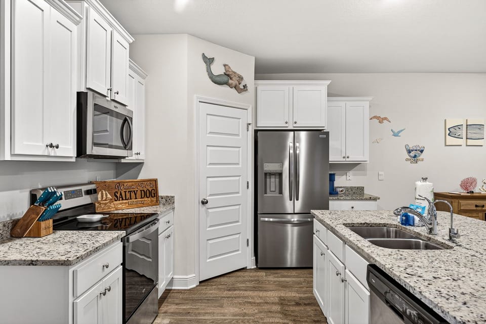 Cook your favorite meals in this fully-equipped kitchen with modern appliances, ample counter space, and coastal-inspired touches welcoming you to prepare delicious vacation dining experiences.