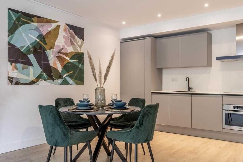 A round dining table with seating for four is positioned between the kitchen and living room.