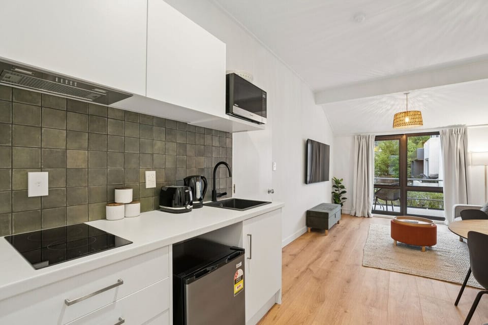 Kitchenette Retreat: Modern kitchen with sleek appliances, natural light, and stylish decor awaits!