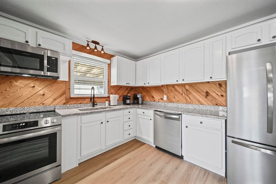 The kitchen opens up to the living room and features brand new cabinetry, granite countertops, and stainless steel appliances.