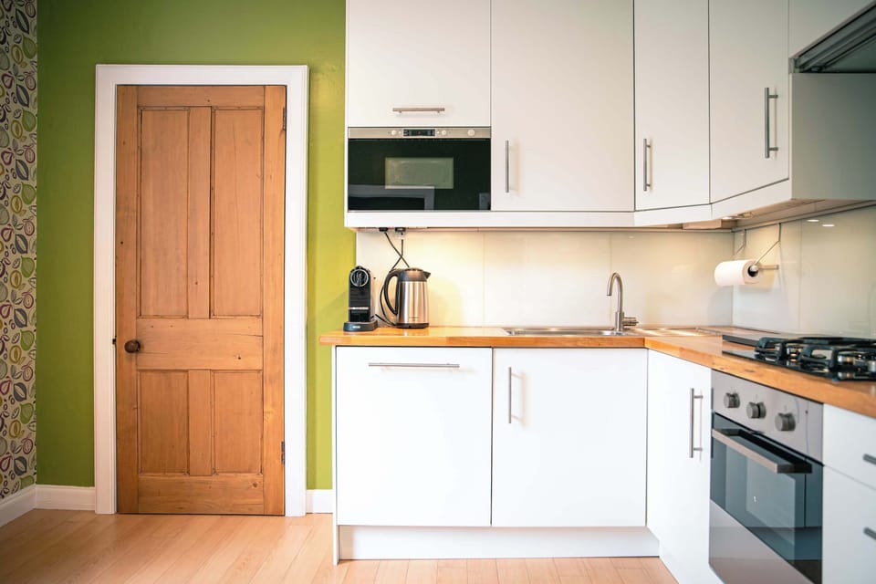 Open kitchen layout w/ bright cabinetry & dining space just steps away