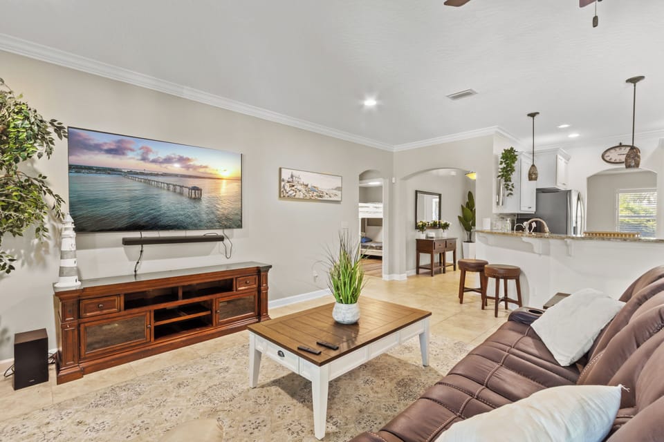 Inviting living room with crown molding, warm wood accents, and an open flow into the kitchen.