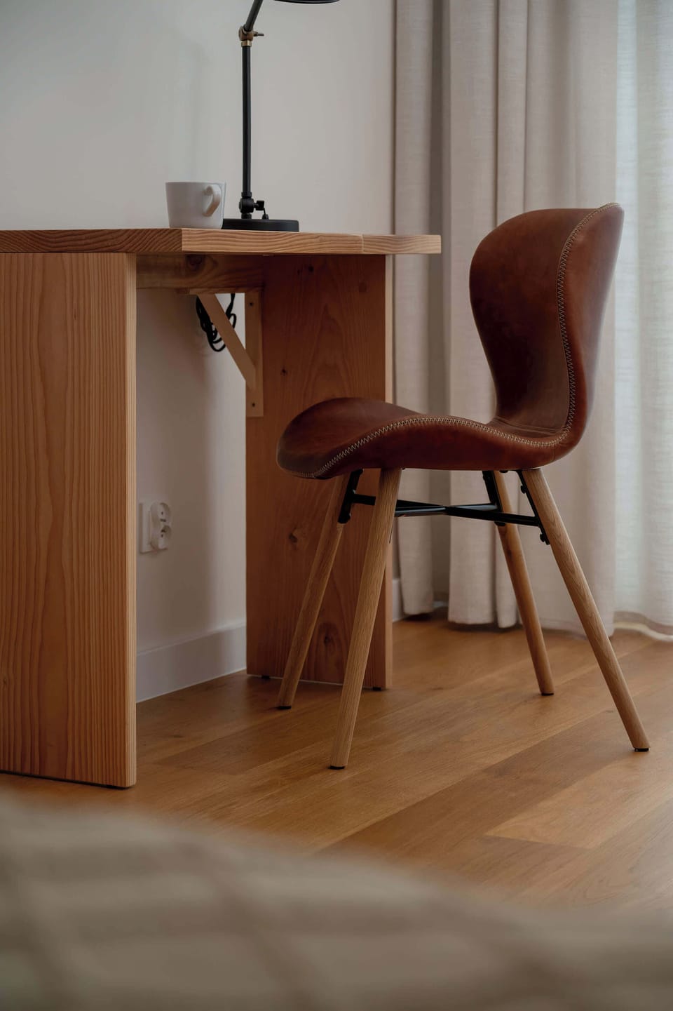 A work corner with high chair and warm wooden flooring.