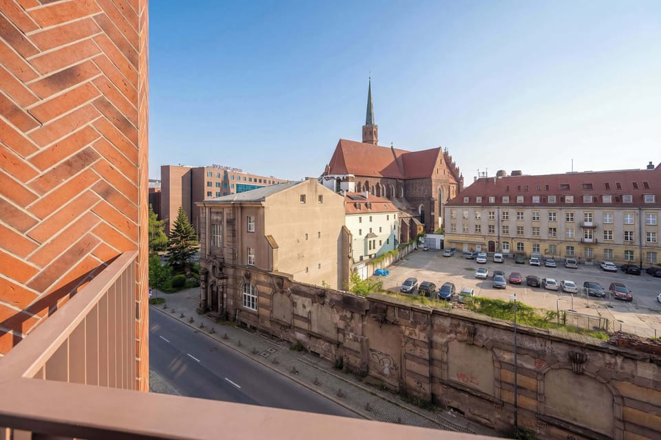 A balcony perspective overlooking a canal-side area and surrounding city buildings.