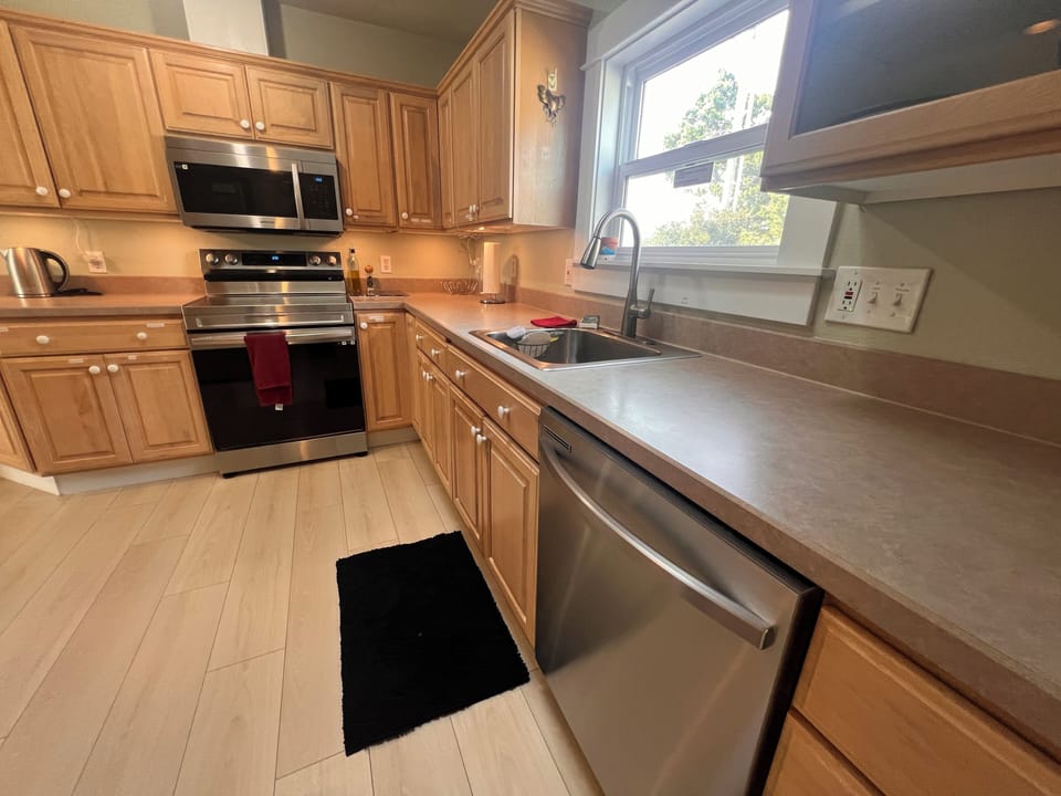 Your fully equipped kitchen features modern stainless-steel appliances, ample cabinet storage, and everything you need to prepare meals just like home.