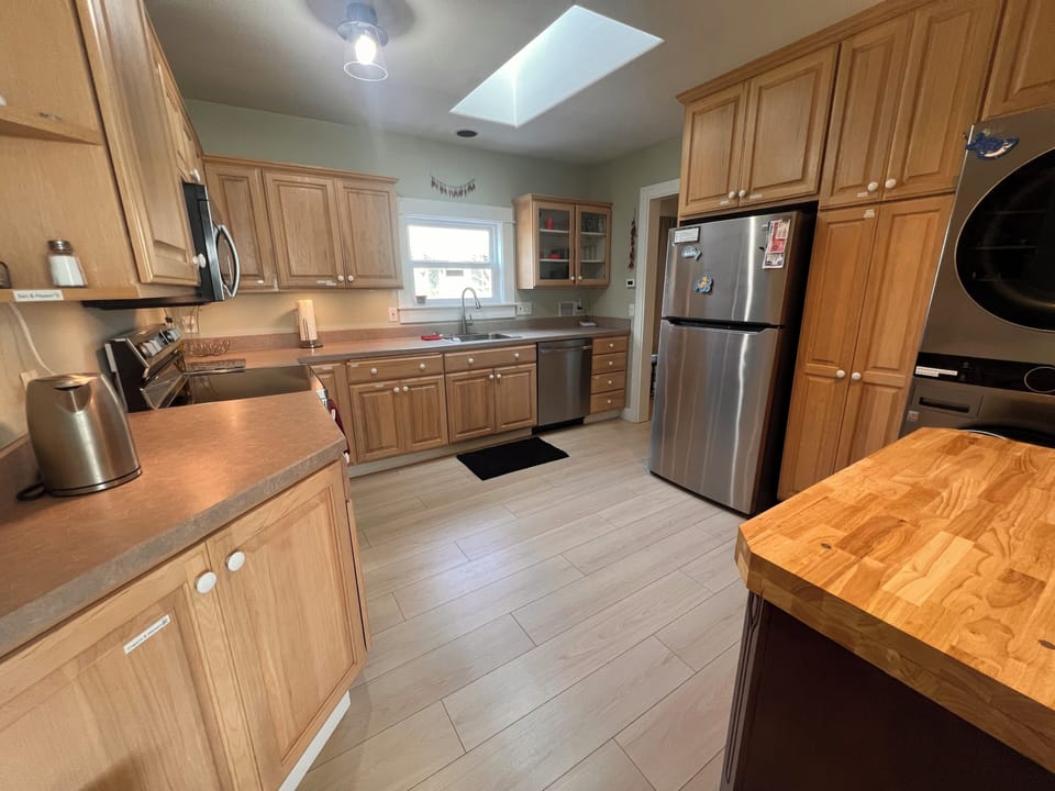 A fully equipped kitchen awaits with modern appliances, warm wood cabinetry, and ample prep space for your culinary adventures during your stay.