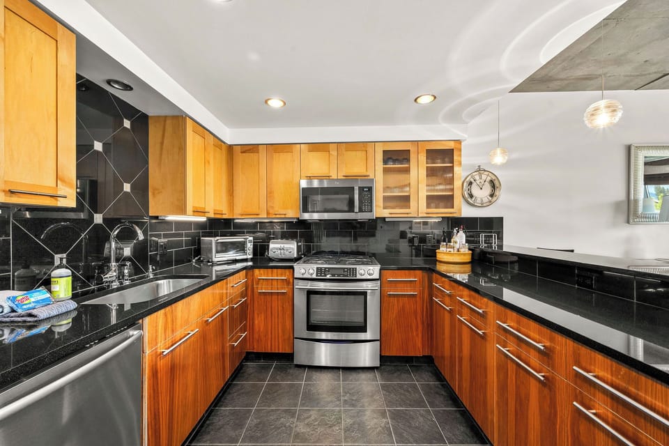 Your dream kitchen awaits with warm wood cabinets, sleek black granite counters, and stainless appliances. Picture yourself preparing meals in this stylish, fully-equipped space.