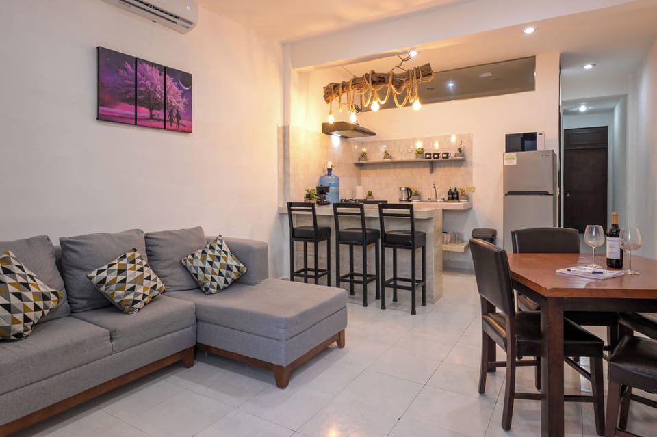 Bright open-plan lounge with dining area, breakfast bar, and modern kitchen