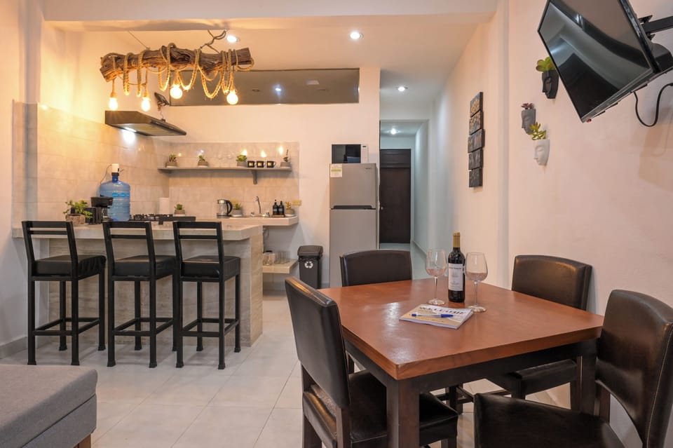 Bright open dining area with modern kitchen, breakfast bar, and TV