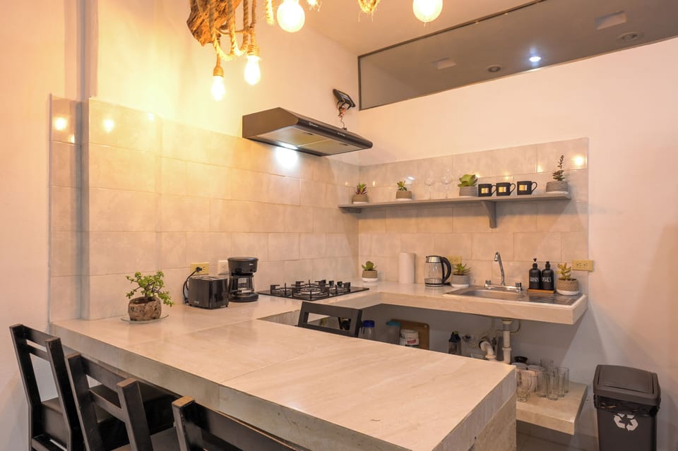 Modern kitchen with breakfast bar, warm lighting, and coffee setup