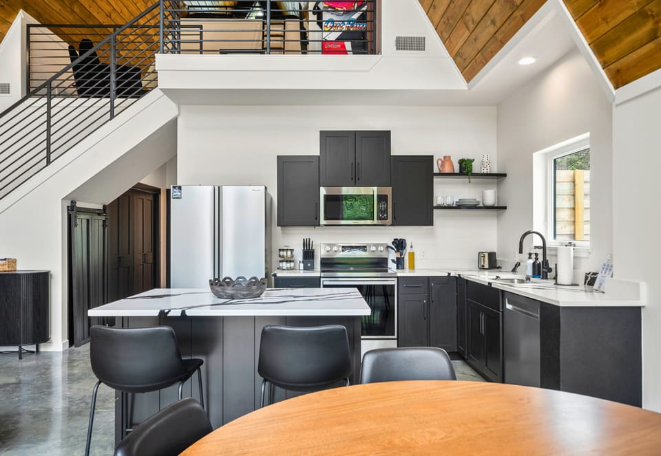 The kitchen keeps it sleek and functional with a center island, high-top seating, and everything you need to cook or snack in style.