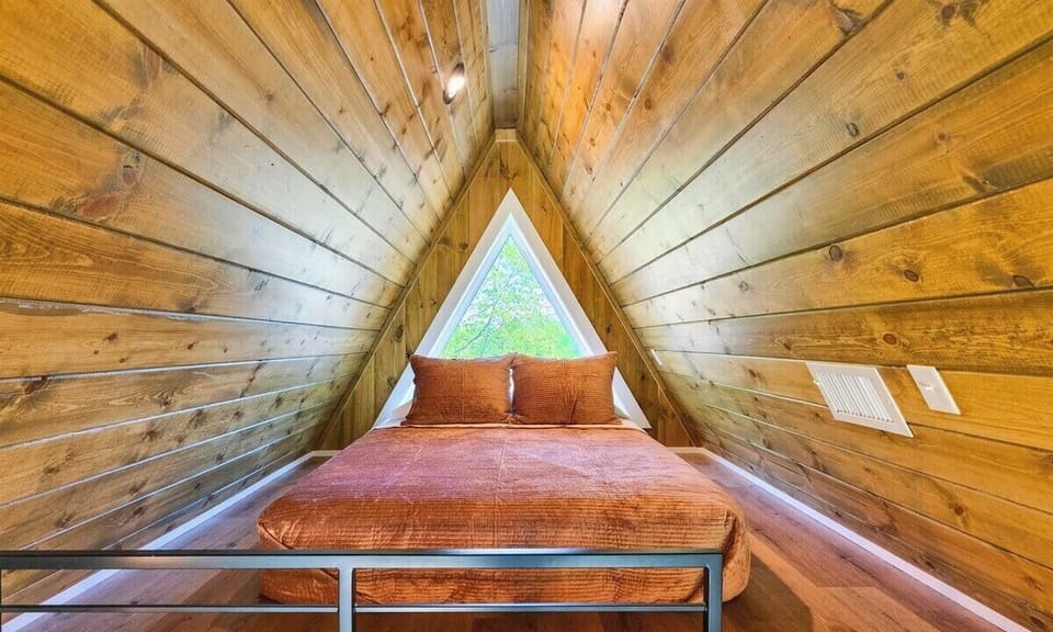 This cozy loft bed is tucked beneath wood beams and soft lighting—perfect for those who love a peaceful, tucked-away nook.