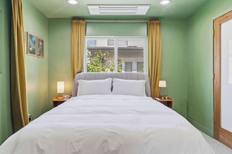 Bedroom — Sage Green Walls, Gray Upholstered Headboard, Matching Nightstands & Mustard Curtains (Angle 2)