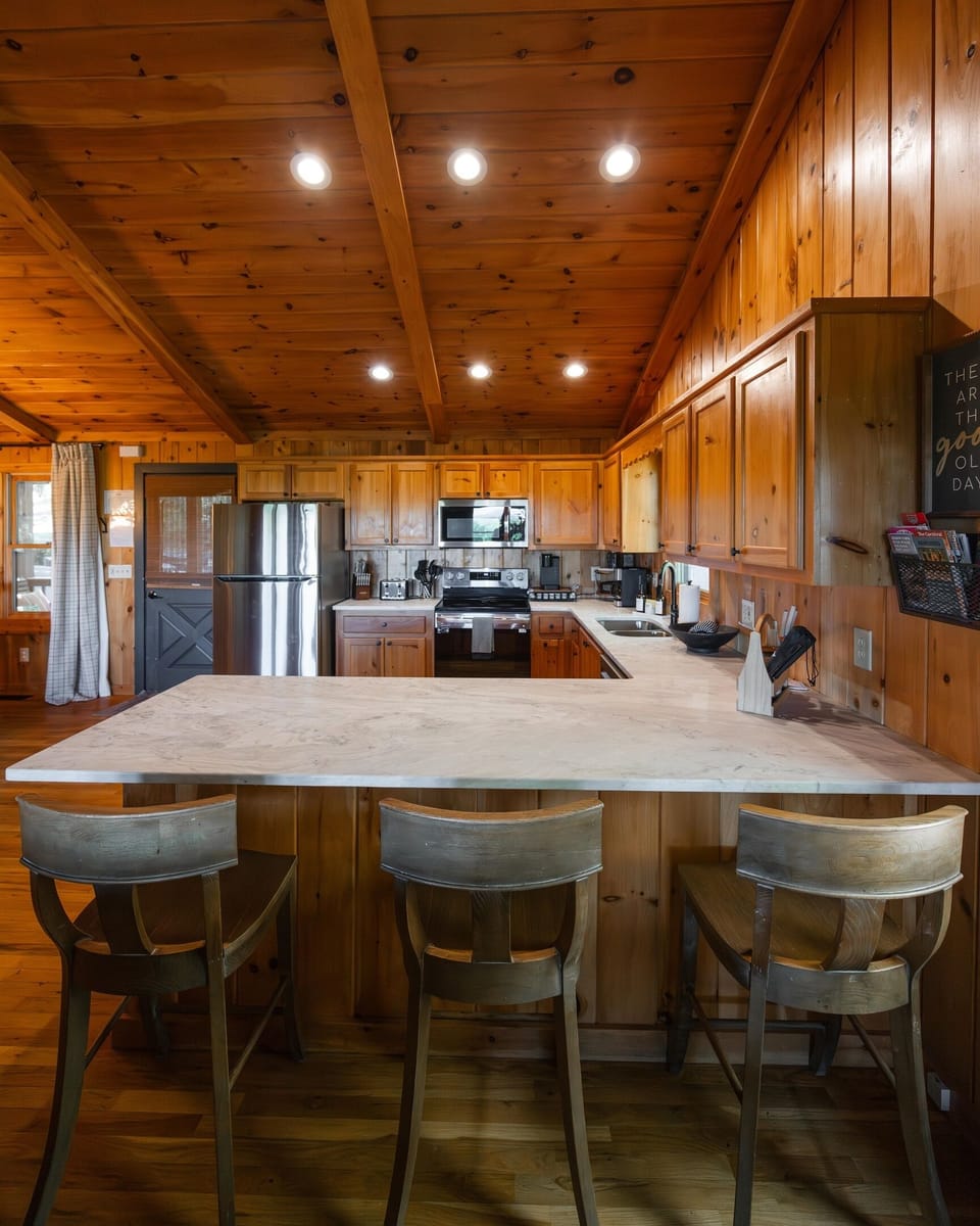 Fully stocked kitchen with stainless steel appliances, quartz countertops, and island seating - perfect for cooking, gathering, and staying in.