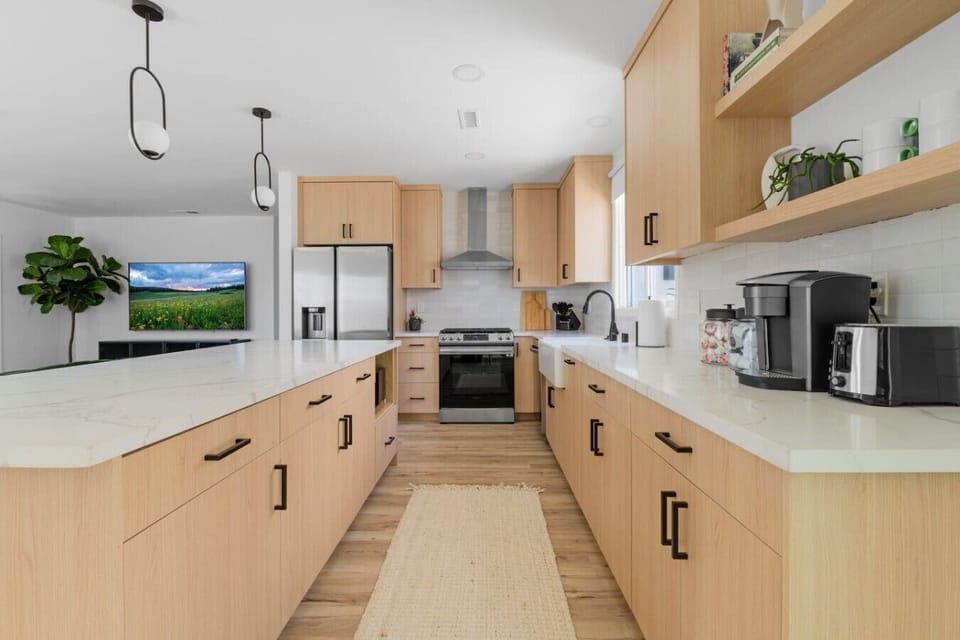 Fully equipped chef’s kitchen with ample counter space, stainless steel appliances, and a bright open design.