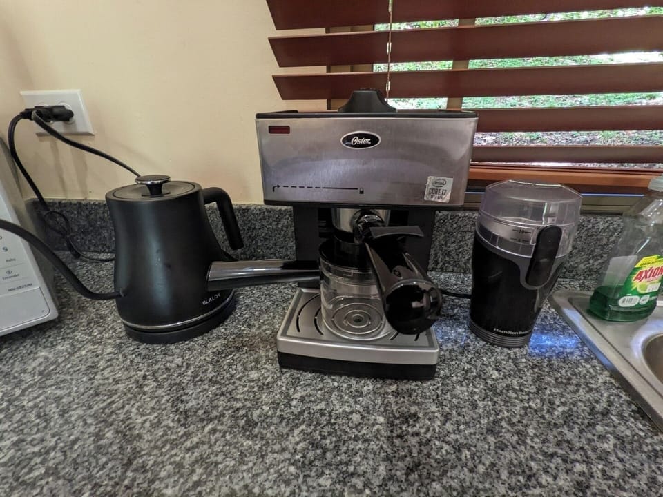 Espresso maker, grinder, fast-boil tea kettle, and a drip coffee maker below in the cabinet.  