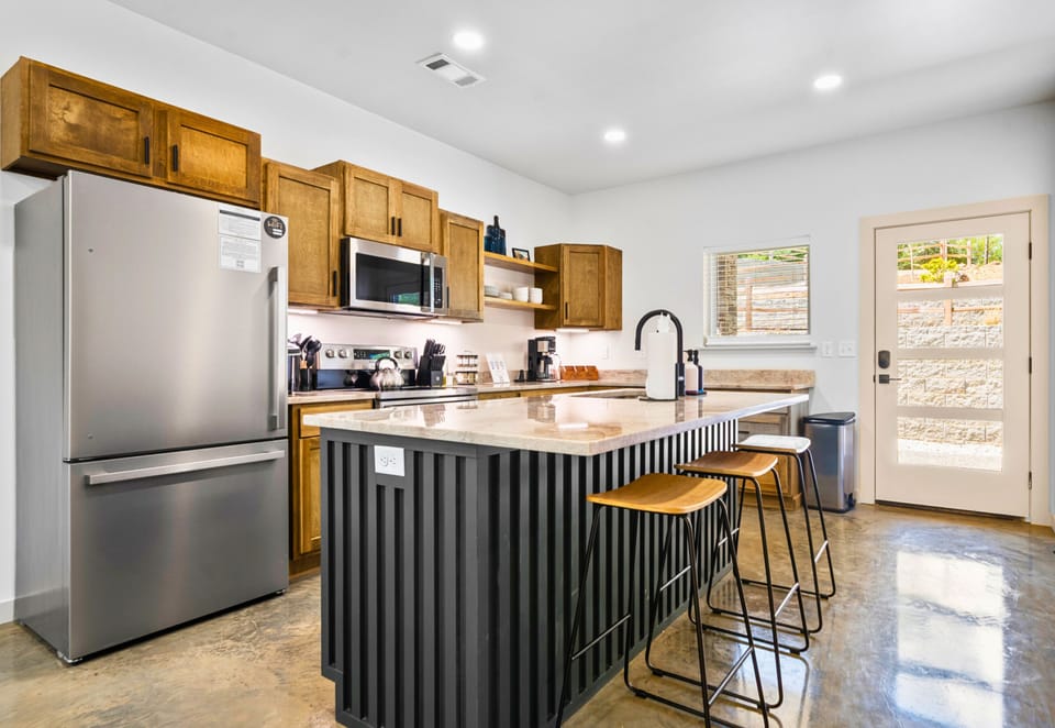 Fully stocked kitchen with island seating and modern appliances—cooking is a breeze here.