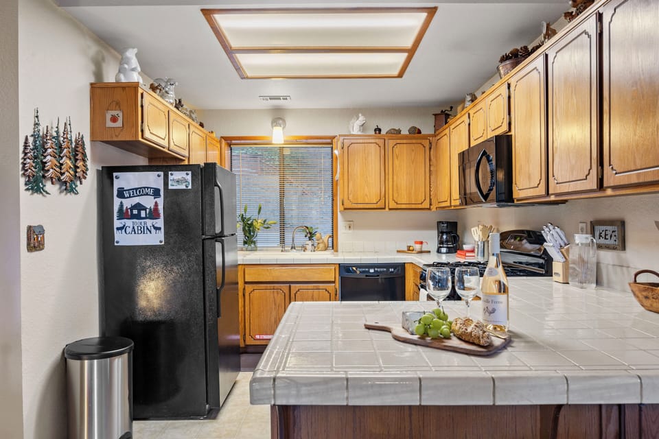Rustic, fully equipped kitchen with warm wood cabinetry, island prep space, and everything you need for easy cabin meals.