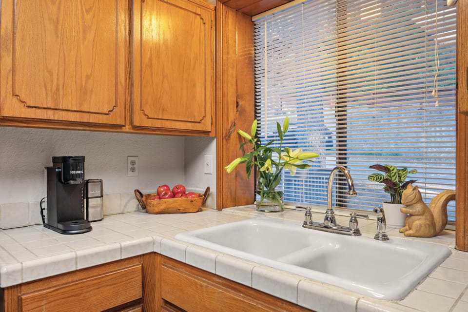 Rustic, fully equipped kitchen with warm wood cabinetry, island prep space, and everything you need for easy cabin meals.