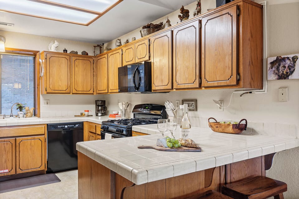 Rustic, fully equipped kitchen with warm wood cabinetry, island prep space, and everything you need for easy cabin meals.