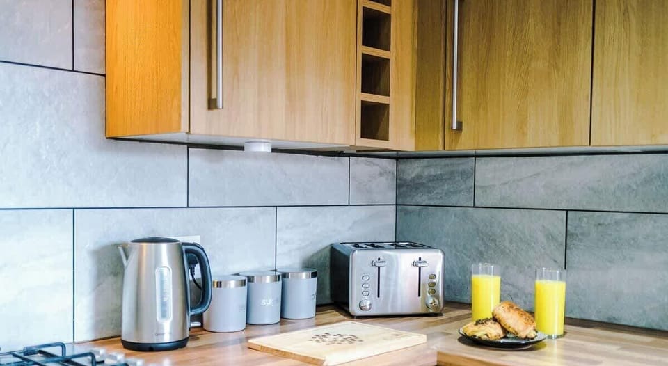 Modern fully equipped kitchen with wooden cabinets.
Includes oven, hob, fridge, microwave, toaster, and kettle.
Perfect for cooking meals during long or short stays.