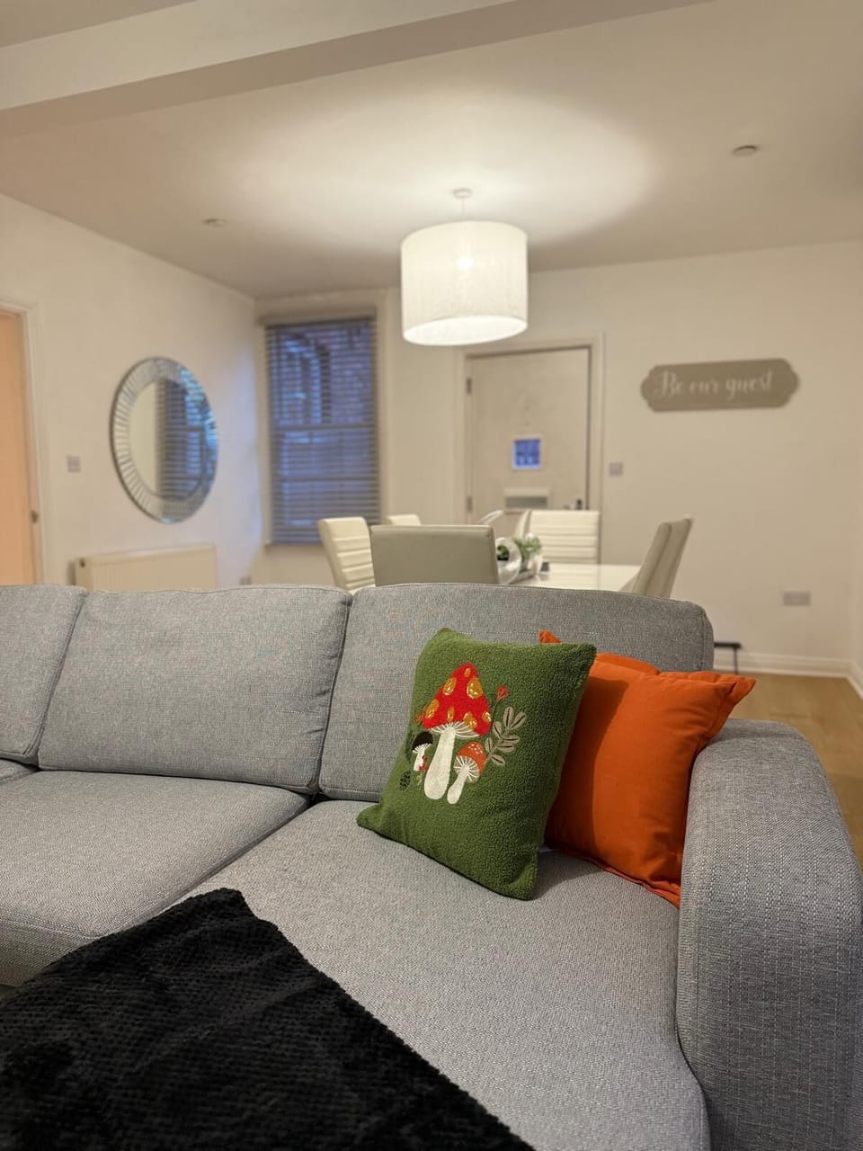 Cozy living area with modern furnishings, vibrant green accents, and a smart TV for entertainment.