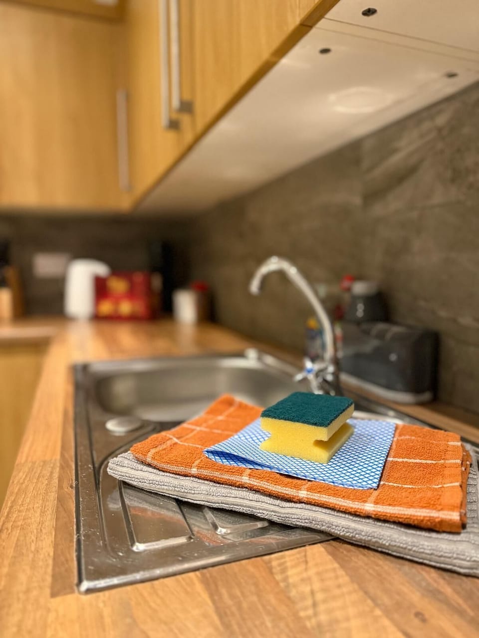Well-equipped kitchen with neatly arranged cleaning essentials, offering a cozy and practical setup.