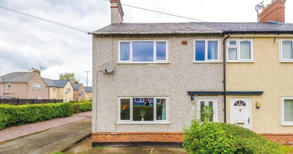 A neat and welcoming end-terrace home with a private driveway and side access.
The property features a gravel parking area and a well-maintained exterior.
Situated in a quiet residential street, ideal for families or contractor stays.